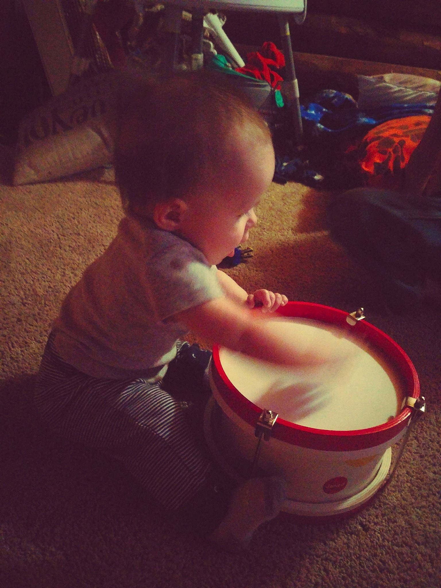 Kannon is registered to the contest to win money with this photo: baby, chest, child, drum, drumhead, eyewear, finger, flooring, fun, hand_drum, human_body, human_leg, idiophone, lap, membranophone, mouth, musical_instrument, person, thigh, toddler