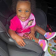 Novi joined the competition — help win amazing prizes! child, toddler, car_seat, pink_bow, pink_shoes, smiling, curly_hair, baby_bib, car_interior, toy_box, balloon, happy, cute, infant, sitting, portrait, clothing, footwear, person, indoors