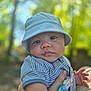 baby, child, face, hat, bucket_hat, striped_shirt, hand, outdoor, nature, greenery, portrait, closeup, infant, young_child, person, cute, skin, expression, holding, daylight