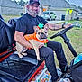 King Louie is registered to the contest to win money with this photo: beard, black_seat, cap, car, cooler, dog, driveway, french_bulldog, garage, glasses, golf_cart, house, lawn, man, porch_light, pumpkin_costume, snacks, steering_wheel, string_lights, tattoo