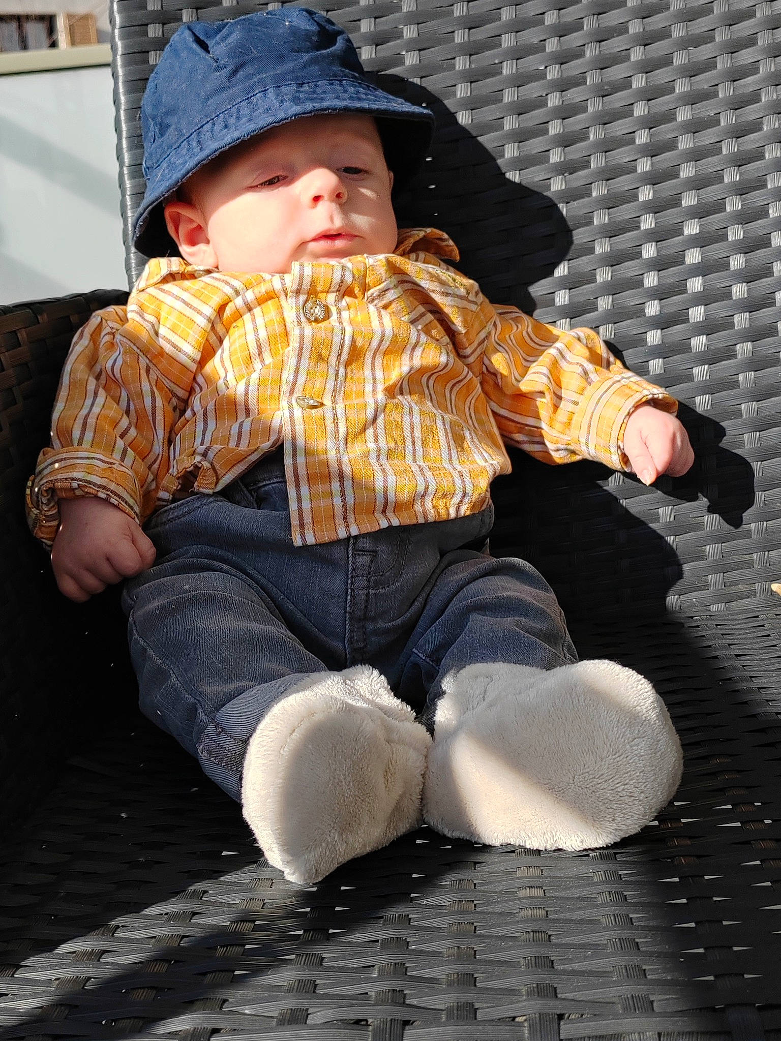 Elio a rejoint le concours — aidez-le/la à gagner de superbes lots ! baby, beanie, cap, child, comfort, denim, flooring, fun, headwear, human_leg, lap, pattern, person, plaid, road_surface, sitting, sleeve, toddler, winter