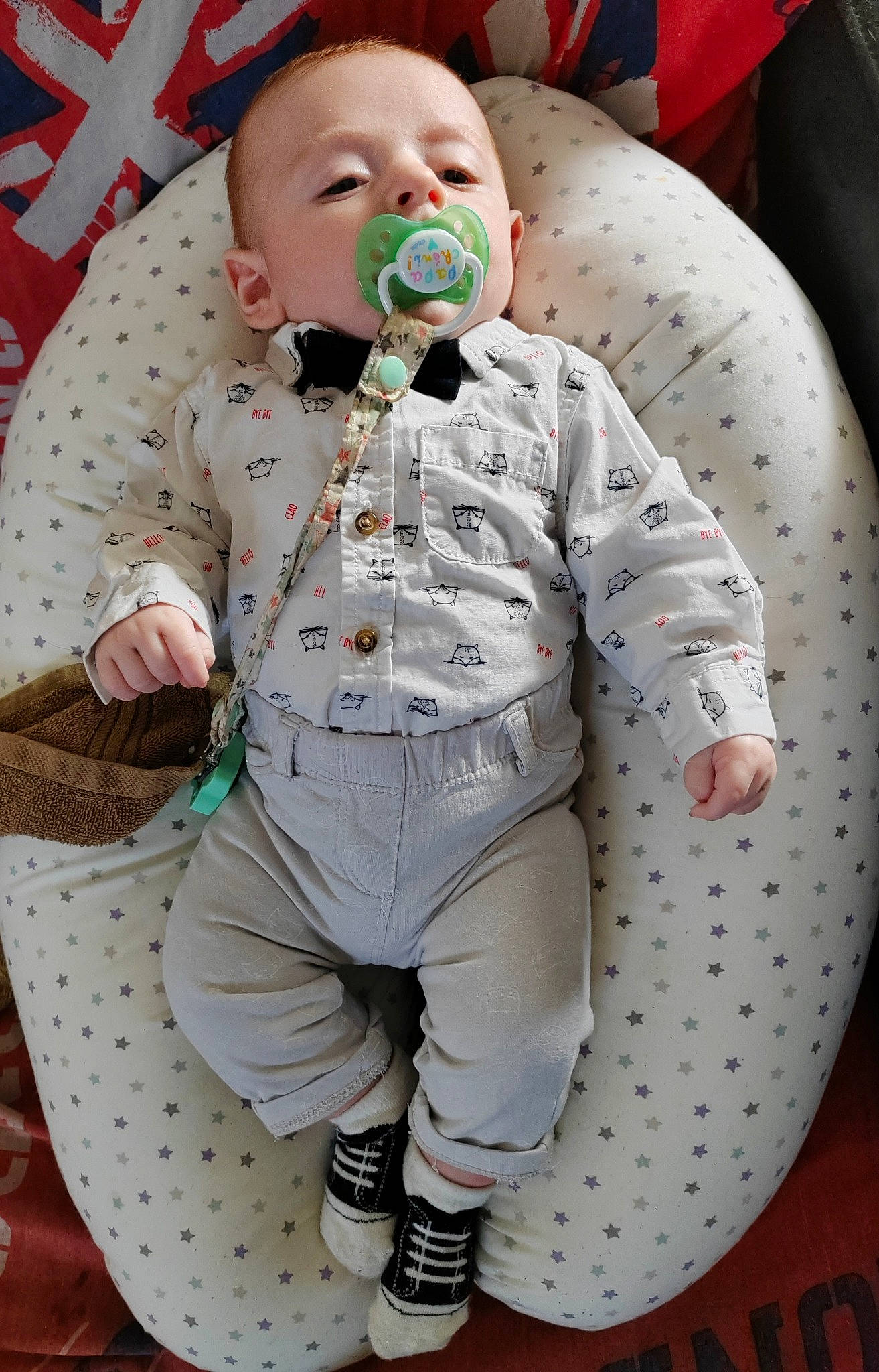 Elio a rejoint le concours — aidez-le/la à gagner de superbes lots ! baby, baby_products, baby_toddler_clothing, child, helmet, pattern, person, personal_protective_equipment, sitting, sleeve, suit, toddler, white