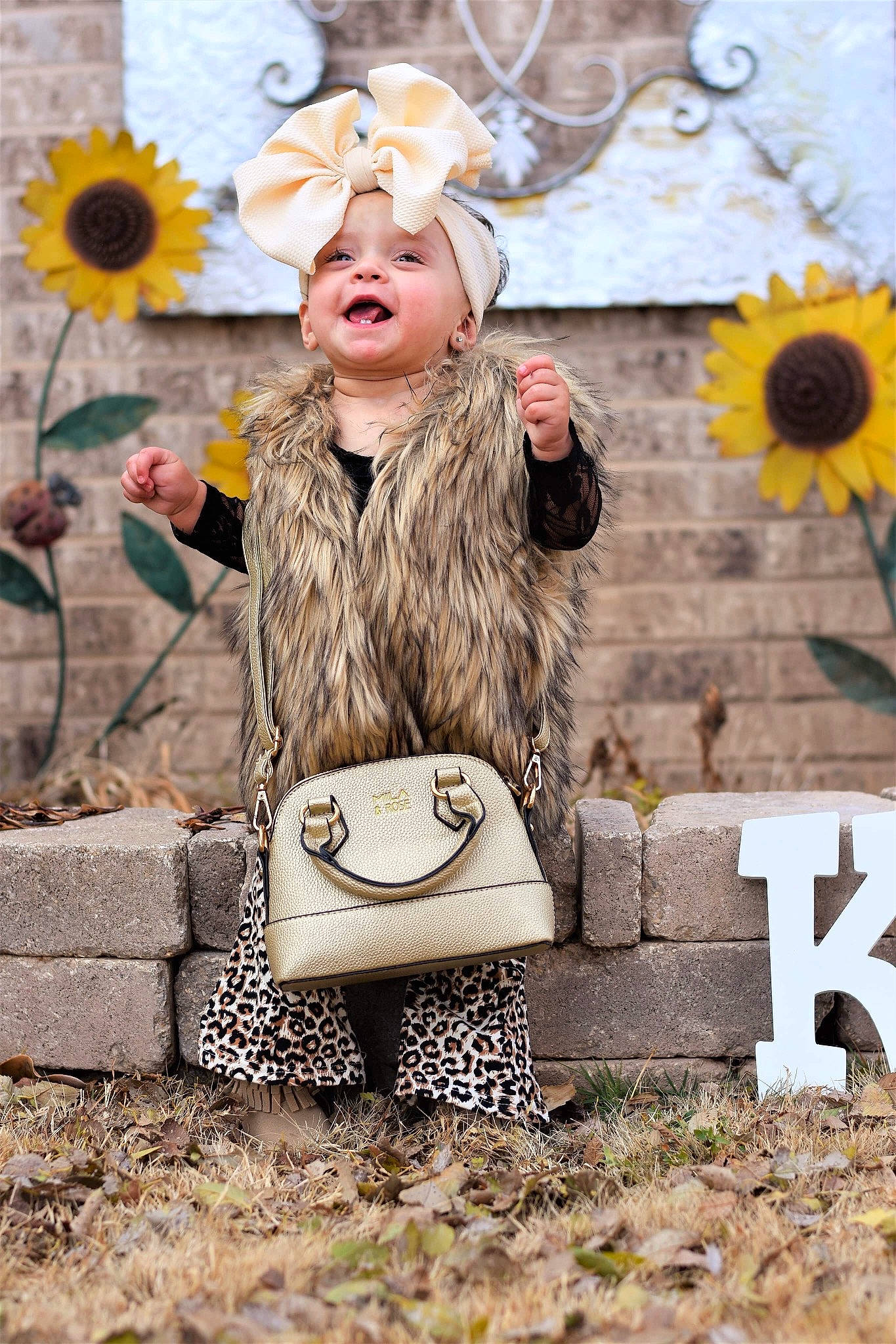 Kaizlee is registered to the contest to win money with this photo: blond, child, child_model, fashion, fashion_accessory, flower, fur, happy, hat, headgear, outerwear, person, plant, smile, spring, street_fashion, style, sunflower, toddler, yellow