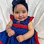 baby, child, smiling, dress, blue_dress, red_dress, headband, navy_headband, happy, cute, infant, sitting, blanket, white_blanket, portrait, closeup, person, skin, hand, face