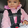 toddler, child, car_seat, pink_jacket, blanket, seatbelt, car_interior, portrait, baby, straps, window, greenery, face, smiling, hair_tie, safety, cute, young_child, casual_clothing, indoors