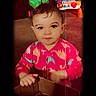 toddler, child, pink_clothing, cardboard_box, indoor, playtime, toy, colorful, floor, carpet, face, portrait, curious, standing, young_child, baby, home, vignette, bright_colors, casual