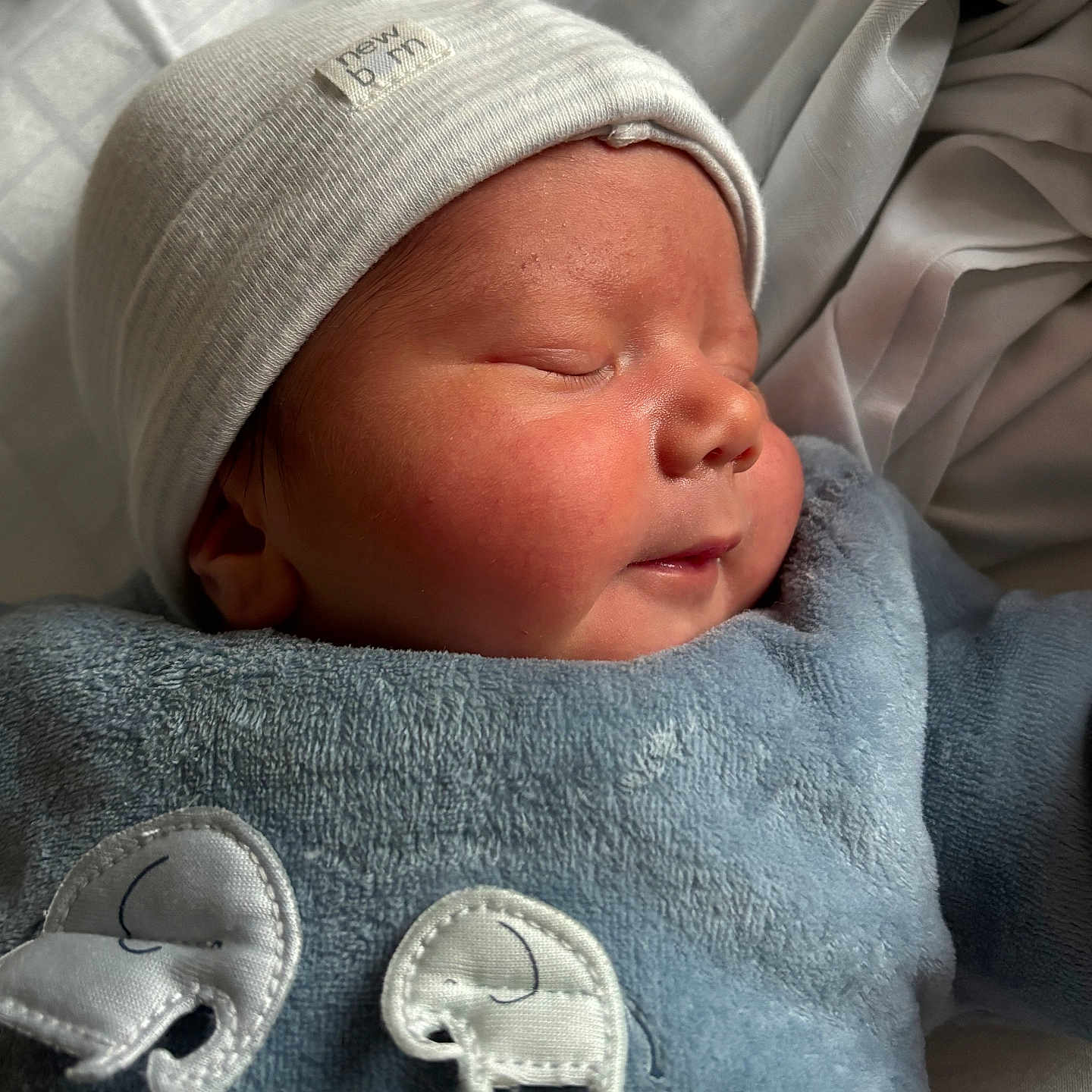 Owen a rejoint le concours — aidez-le/la à gagner de superbes lots ! apparel, baby, blue_outfit, child, closeup, cozy, cute, cute_baby, elephant_patch, face, hat, indoors, infant, newborn, peaceful, portrait, resting, skin, sleeping, soft_lighting
