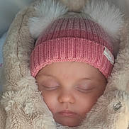 Ilaria Maria participe au concours pour gagner de l'argent avec cette photo : baby, sleeping, pink_hat, pom_poms, beige_coat, blanket, soft_texture, cute, infant, warm_clothing, face, closed_eyes, bundle_up, cozy, winter, child, portrait, indoor, headwear, peaceful