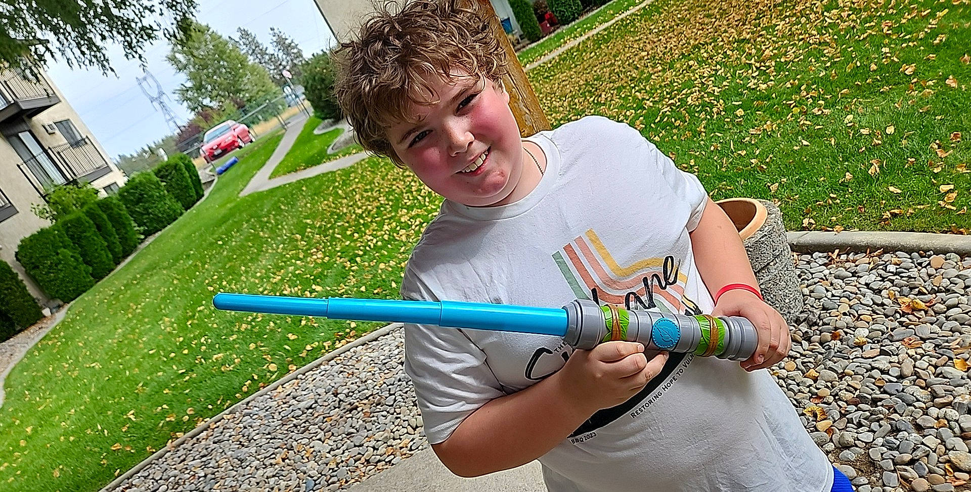 Chayton is registered to the contest to win money with this photo: child, electric_blue, fun, grass, green, happy, joy, leisure, musical_instrument, outdoor_play_equipment, people_in_nature, person, plant, play, recreation, shorts, sky, smile, t_shirt, tree