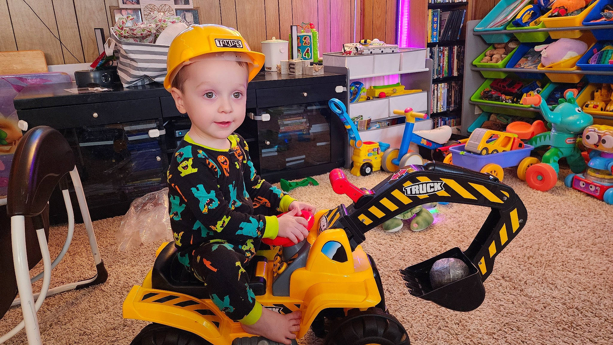 Jaxen joined the competition — help win amazing prizes! automotive_tire, baby_toys, baseball_cap, child, event, fun, leisure, person, play, product, recreation, riding_toy, shelf, sitting, smile, t_shirt, tire, toddler, toy, toy_vehicle