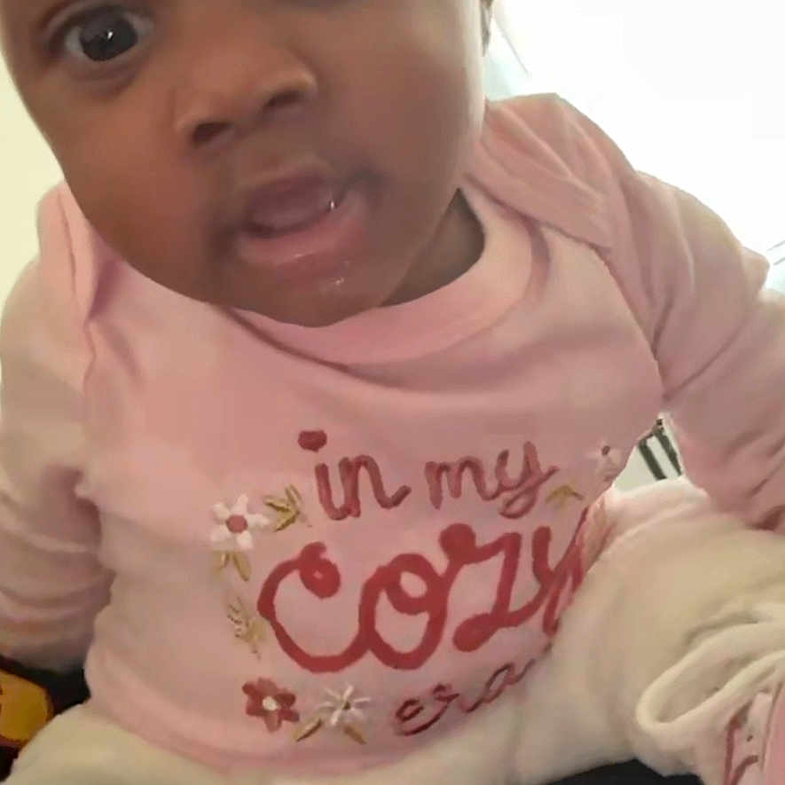 Nymani is registered to the contest to win money with this photo: baby, child, infant, pink_clothing, face, eyes, mouth, sitting, indoor, window, light, curious, portrait, person, young_child, cute, soft_lighting, casual, cozy, expression
