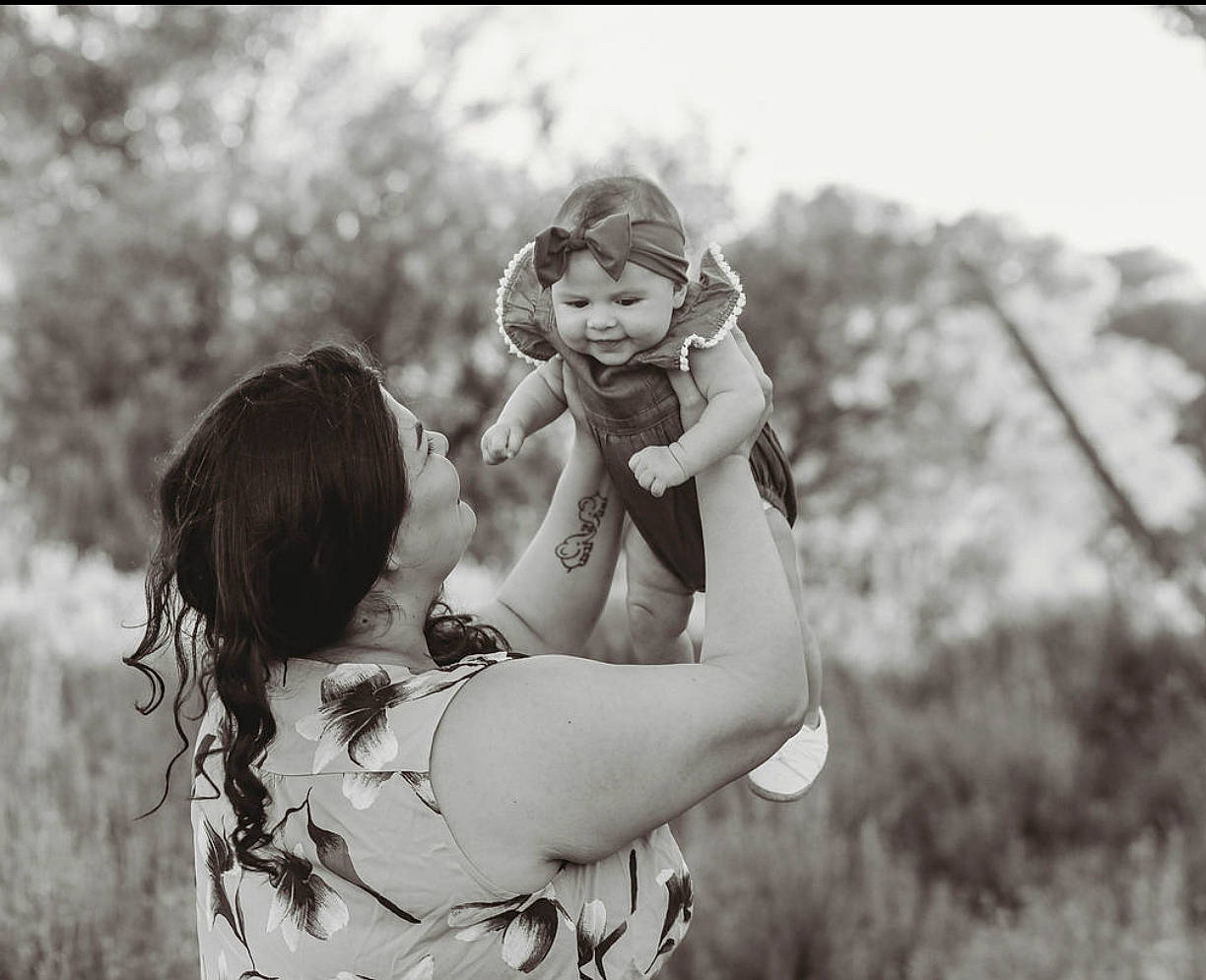 Leena is registered to the contest to win money with this photo: baby, black_and_white, dress, flash_photography, fun, gesture, grass, grassland, happy, human, joy, meadow, monochrome, monochrome_photography, people_in_nature, person, plant, skin, smile, style