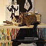 cat, tabby_cat, furniture, dresser, painting, artwork, silhouette, indoor, pet, relaxed, fluffy, colorful, portrait, animal, decor, wall, eyes, tail, resting, cozy