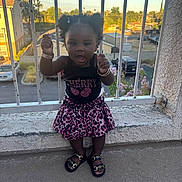Zaniyah is registered to the contest to win money with this photo: bracelets, child, concrete, daytime, fashion, footwear, girl, happy, outdoor, pigtails, railing, residential_area, sandals, skirt, smiling, standing, sunlight, toddler, top, urban