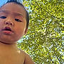 bare_chest, child, close_up, curious, daylight, expression, face, head, leaves, natural_light, nature, outdoor, person, portrait, skin, sky, sunlight, toddler, tree, young