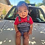 anklet, baby, background, blue_overalls, car, child, daylight, face, feet, happy, hood, nature, outdoor, person, portrait, red_shirt, shadow, smiling, sunlight, toddler