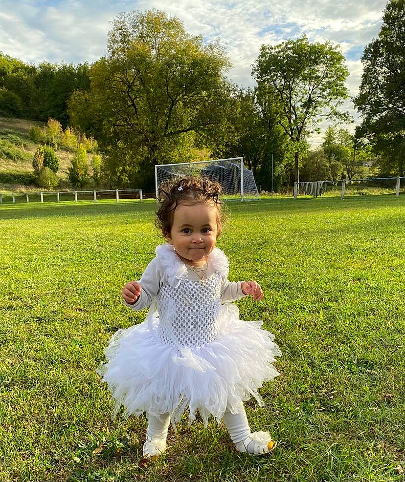 Louanaëlle participe au concours pour gagner de l'argent avec cette photo : baby_toddler_clothing, botany, cloud, dress, fun, grass, grassland, green, happy, joy, leaf, nature, people_in_nature, person, plant, sky, smile, summer, sunlight, toddler