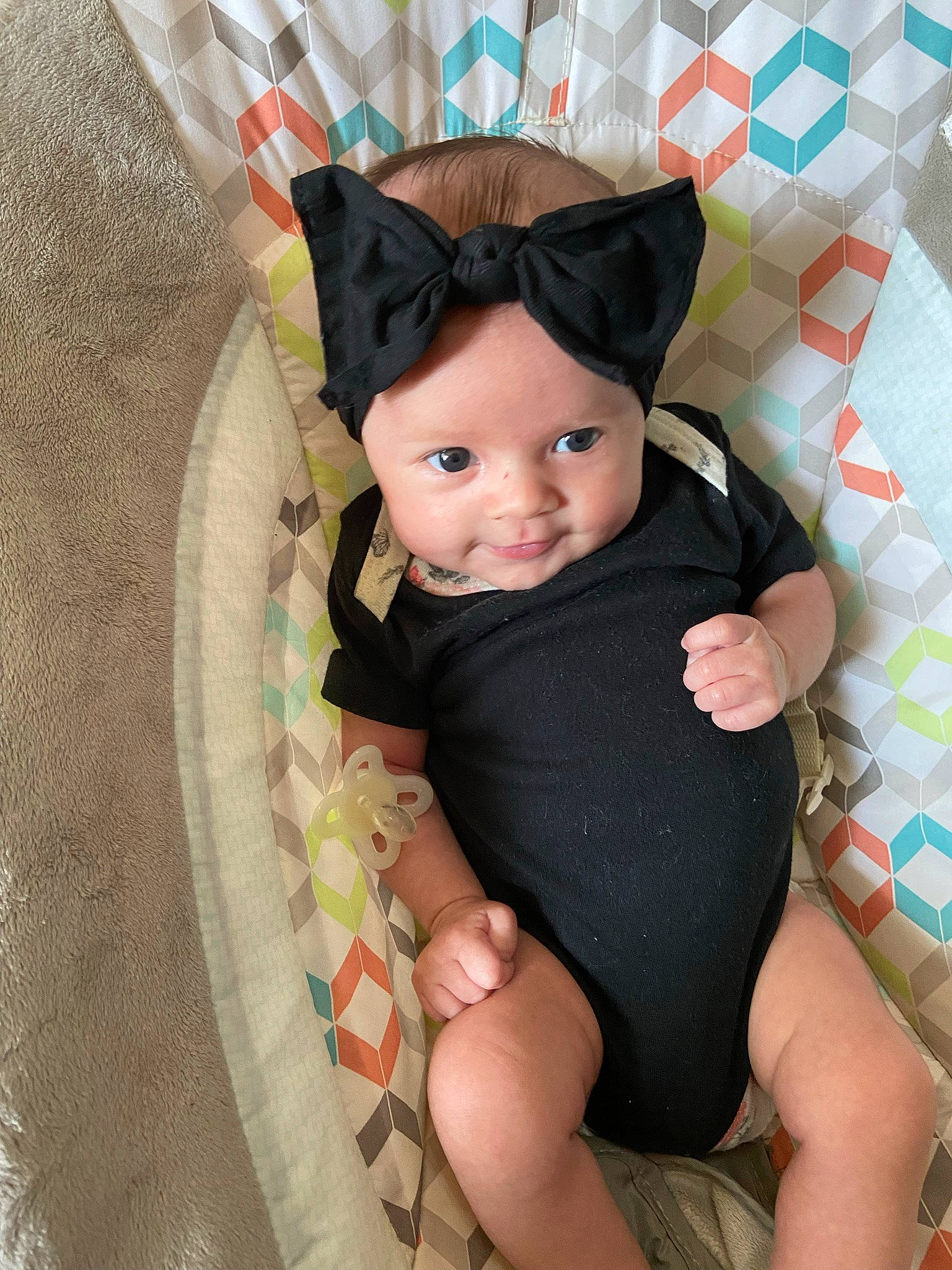 Evelyn joined the competition — help win amazing prizes! baby, baby_products, baby_toddler_clothing, child, comfort, face, fun, head, headwear, human_leg, knee, lap, party_hat, pattern, person, pink, product, sitting, skin, sleeve