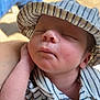 baby, sleeping, hat, striped_clothing, infant, peaceful, closeup, face, hand, newborn, skin, soft_light, portrait, resting, cute, child, casual, comfortable, outdoor, relaxation