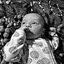 autumn, baby, black_and_white, blanket, candy_corn, child, closeup, cozy, cute, face, hand, holiday_theme, infant, lying_down, monochrome, onesie, patterned_clothing, pumpkin_candy, soft_texture, thumb_sucking