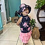 casual, child, cute, decor, floral_clothing, furniture, girl, happy, hat, home, indoor, pink_skirt, plant, playful_pose, portrait, sandal, smiling, standing, tile_floor, young_child