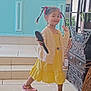 Elsa participe au concours pour gagner de l'argent avec cette photo : braided_hair, cabinet, cardigan, child, decor, furniture, girl, hairbrush, happy, indoor, person, pigtails, pink_shoes, playful, posing, ribbons, smiling, steps, tile_floor, yellow_dress