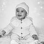Anela is registered to the contest to win money with this photo: baby, infant, smiling, knit_hat, knit_sweater, buttons, sitting, fluffy_rug, toy_beads, hand, portrait, black_and_white, cozy, cute, happy, indoor, warm_clothing, eyes, face, feet