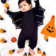 Aaira is registered to the contest to win money with this photo: baby, bare_feet, bat_costume, black_clothing, celebration, child, costume, cute, cute_face, decorations, festive, halloween, holiday, indoors, infant, lying_down, orange_pumpkin_lights, pumpkin_hat, smiling_pumpkin, soft_blanket