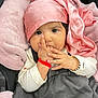 baby, infant, child, face, hand, fingers, headscarf, pink, blanket, clothing, bracelet, cute, indoors, portrait, cozy, soft, sleeping_bag, sitting, closeup, person