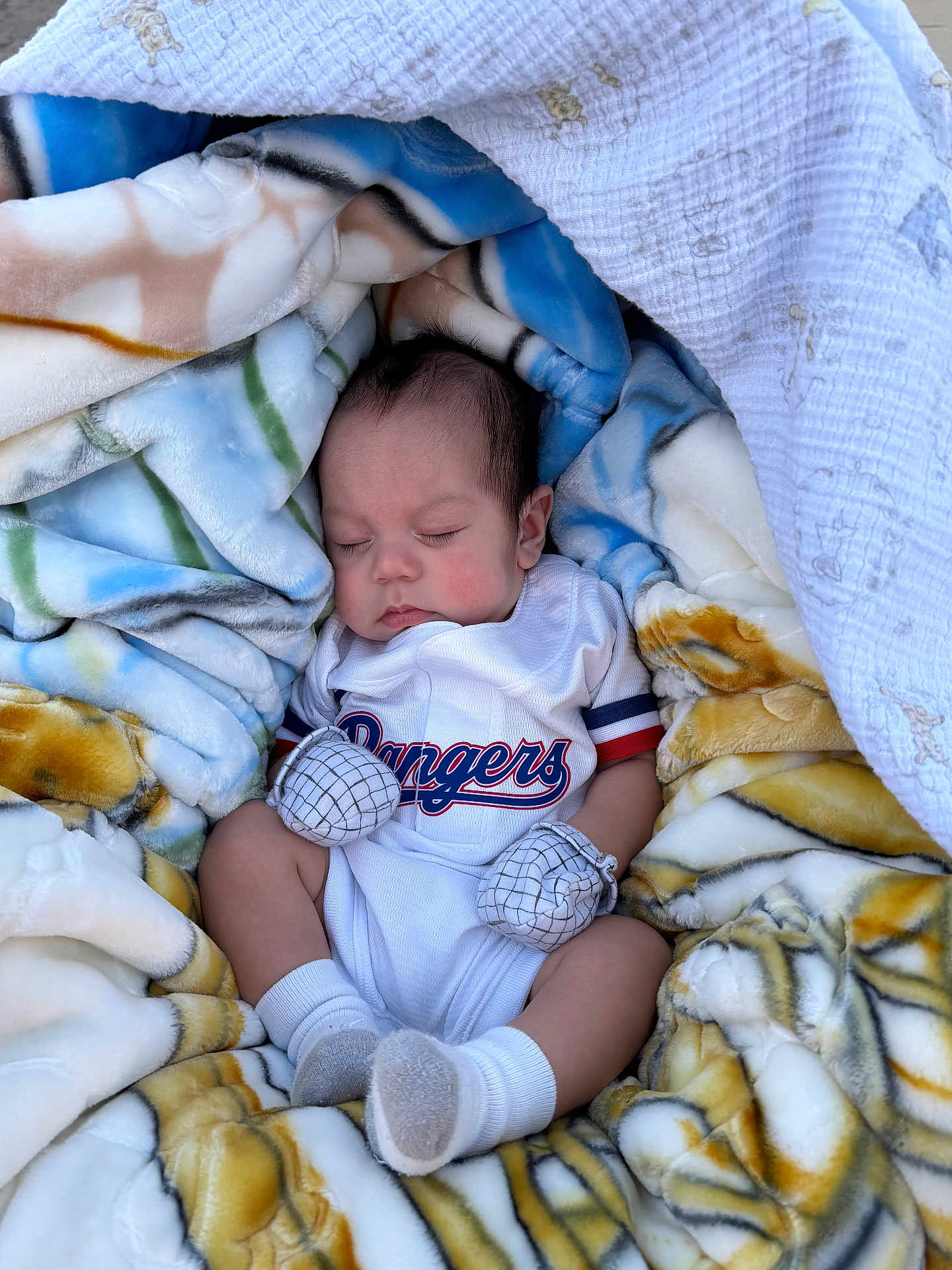 Francisco joined the competition — help win amazing prizes! baby, sleeping, blanket, mittens, socks, clothing, infant, face, person, soft_fabric, patterned_blanket, cute, resting, indoors, portrait, newborn, cozy, relaxation, toddler, sportswear