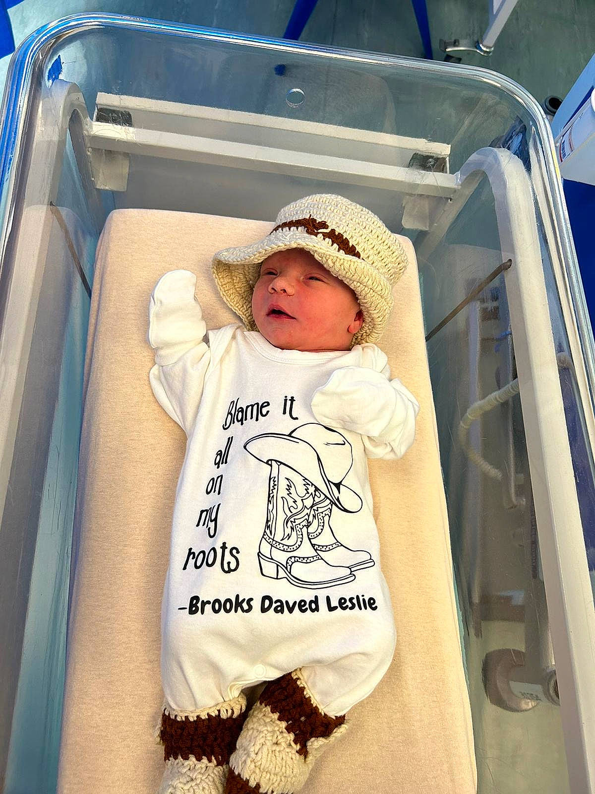 baby, blanket, clothing, crib, face, furniture, hat, head, infantbed, newborn, person