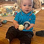 Brooks joined the competition — help win amazing prizes! baby, black_pants, blue_shirt, brown_shoes, casual_clothing, child, colorful, cute, floor_mat, happy, indoor, person, play, playtime, smiling, stuffed_animal, toddler, toys, wooden_floor, young_child