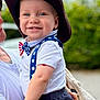 adult, baby, blue_pants, bowtie, child, closeup, cowboy_hat, cute, greenery, hand, happy, hat, outdoor, person, portrait, smiling, suspenders, tattoo, toddler, white_shirt