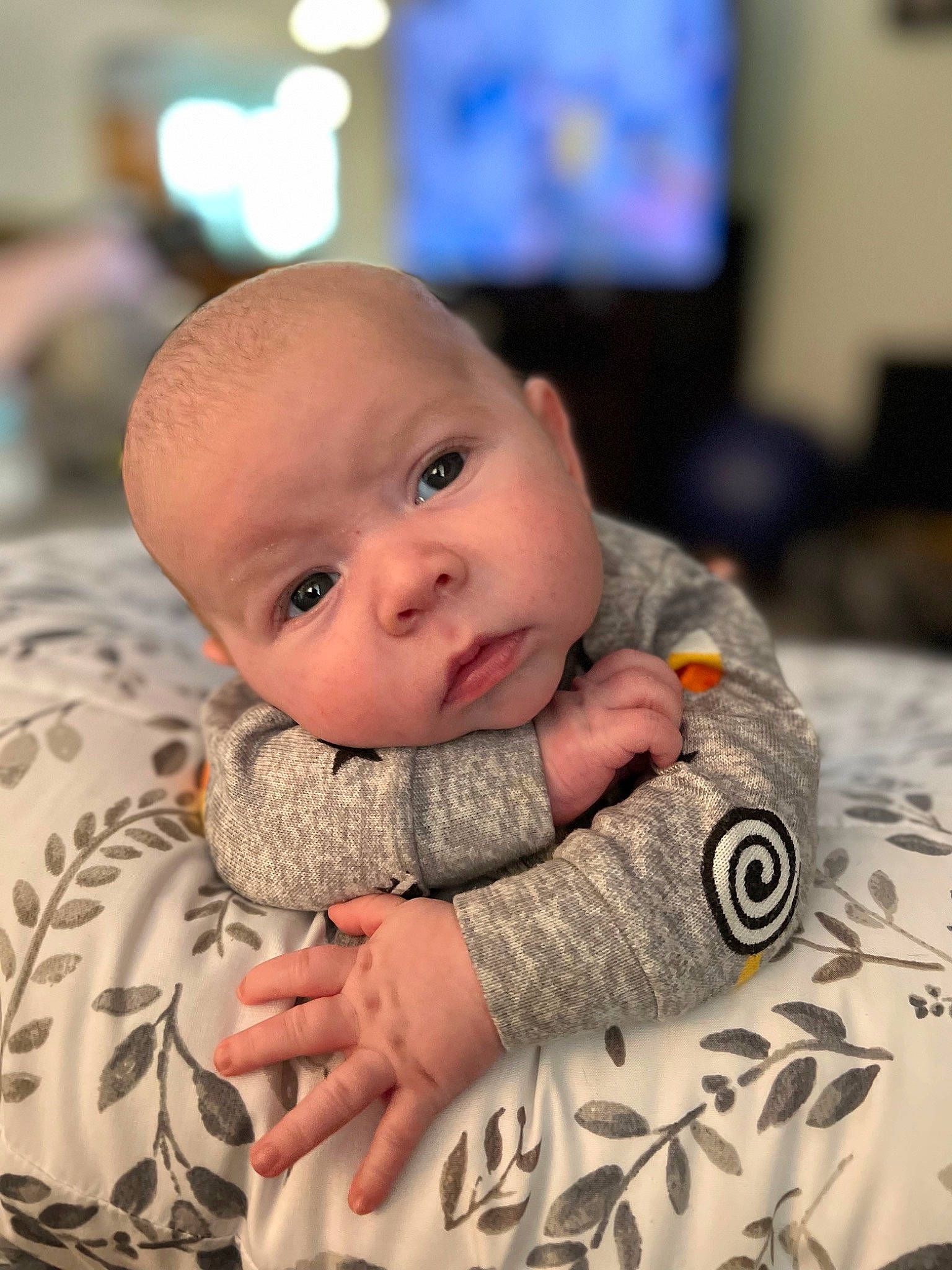 Beckham is registered to the contest to win money with this photo: baby, baby_toddler_clothing, cheek, child, comfort, fun, fur, gesture, happy, human_body, linens, pattern, person, portrait_photography, room, sitting, skin, sleeve, television, toddler