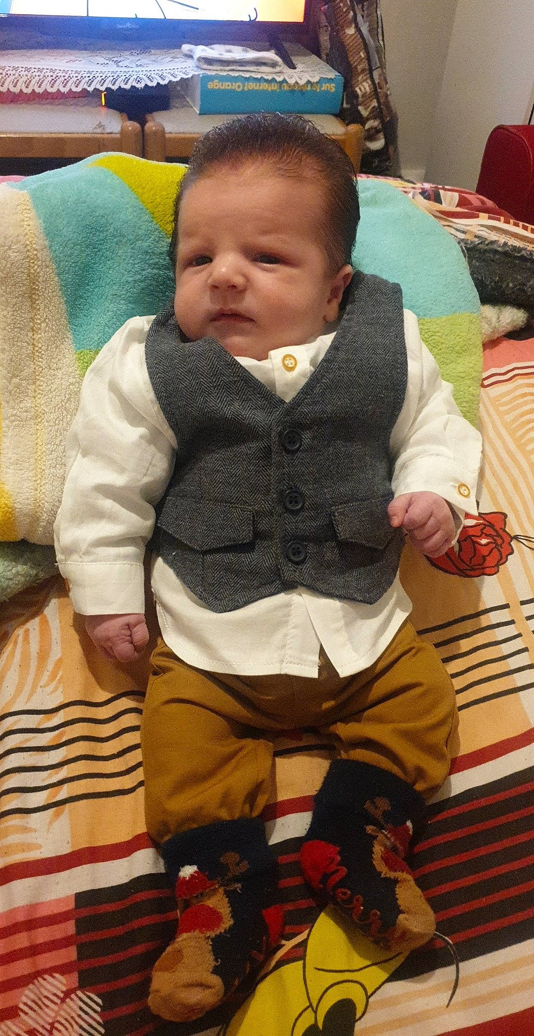 Jovanni a rejoint le concours — aidez-le/la à gagner de superbes lots ! baby, baby_products, baby_toddler_clothing, chair, cheek, child, comfort, flooring, linens, outerwear, pattern, person, room, sitting, skin, sleeve, sock, toddler, wood, wool