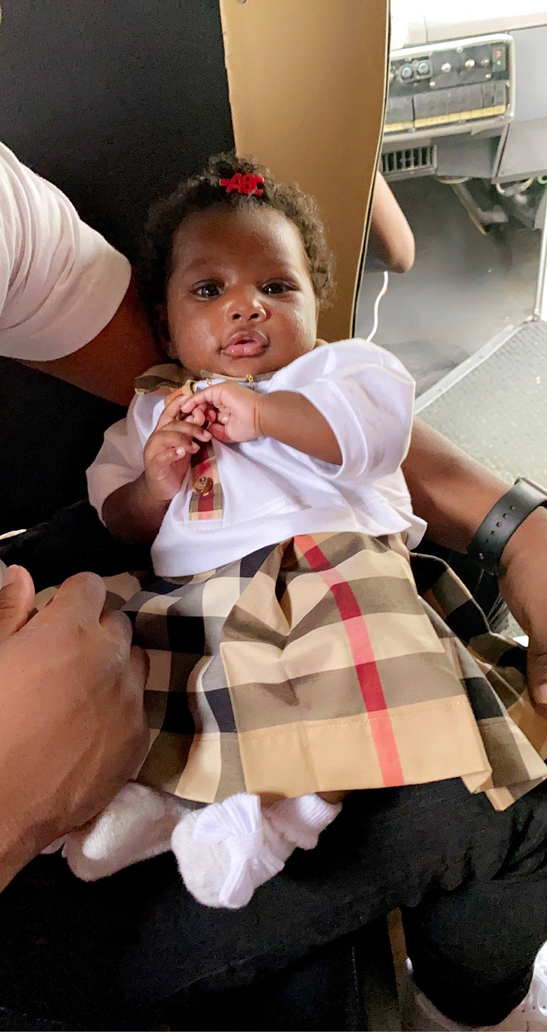 Milani joined the competition — help win amazing prizes! baby, baby_toddler_clothing, child, dress, event, face, finger, food, formal_wear, fun, gesture, hand, happy, nail, pattern, person, plaid, sitting, tartan, thumb