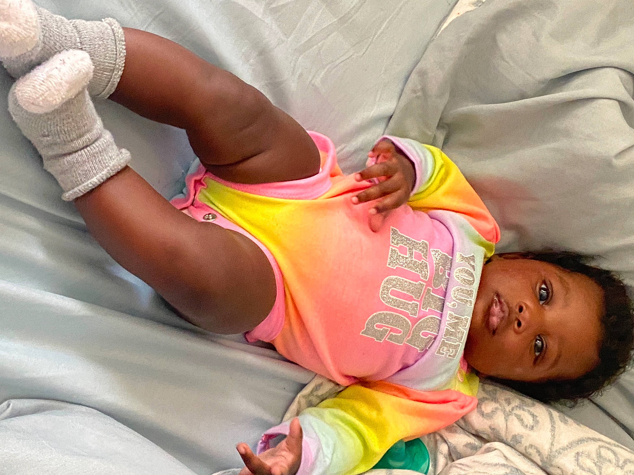 Milani is registered to the contest to win money with this photo: arm, child, comfort, elbow, finger, gesture, hand, human_body, joint, leg, mouth, neck, orange, people, person, pink, product, skin, textile, thigh