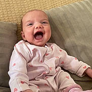 Effy a rejoint le concours — aidez-le/la à gagner de superbes lots ! baby, child, comfortable, couch, cozy, cute, happy, heart_pattern, indoor, infant, pillows, pink_outfit, playful, portrait, seated, smiling, socks, soft, warm, young