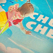 Gracelynn joined the competition — help win amazing prizes! baby, blue_mat, bright_colors, butterfly_wings, child, colorful_clothing, crawling, floor, hair, hand, head, indoor, patterned_wings, pink_strap, playtime, rainbow_skirt, soft_lighting, text_on_mat, toddler, young_child