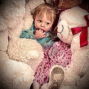Gracelynn is registered to the contest to win money with this photo: baby, child, close_up, clothing, cozy, curious_expression, denim_jacket, fluffy, hand_in_mouth, heart_pattern, pink_tutu, plush, portrait, red_bow, shoe_sole, sitting, soft_texture, stuffed_animal, teddy_bear, toddler