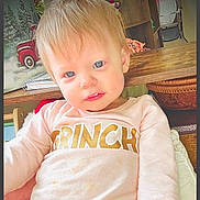 Gracelynn joined the competition — help win amazing prizes! toddler, child, blue_eyes, blonde_hair, pink_shirt, grinch_text, indoors, holiday_painting, wooden_table, basket, notebook, face, portrait, cute, smiling, person, home, cozy, seated, curious