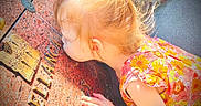 Gracelynn joined the competition — help win amazing prizes! bright_colors, child, close_up, curly_hair, daylight, engravings, exploring, face, floral_dress, girl, hand, outdoor, person, plaque, pony_tail, portrait, stone, sunlight, texture, toddler