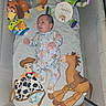 baby, infant, crib, plush_toys, woody, buzz_lightyear, slinky_dog, bullseye, onesie, toy_story, newborn, baby_clothes, soft_toys, cute, child, sleeping_area, three_weeks_old, baby_bedding, smiling, lying_down
