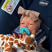 Oakleigh joined the competition — help win amazing prizes! baby, blanket, bow, car_seat, child, closeup, clothing, comfort, cute, face, giraffe, headband, indoor, infant, pacifier, person, plush_toy, rest, seatbelt, soft_toy