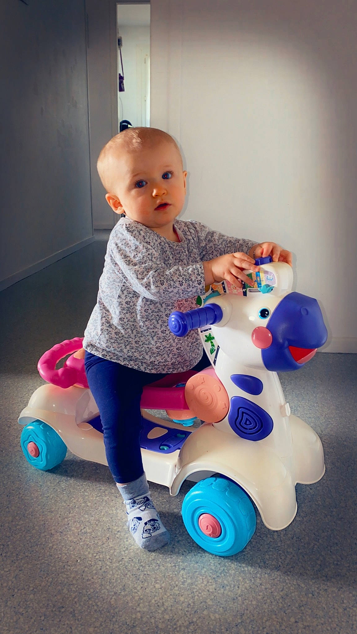 Lyloo participe au concours pour gagner de l'argent avec cette photo : arm, azure, baby, baby_toddler_clothing, child, electric_blue, facial_expression, fun, hand, happy, head, human_body, person, purple, riding_toy, sitting, skin, surprise, tire, toddler