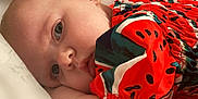 Rynleigh joined the competition — help win amazing prizes! baby, close_up, infant, face, eyes, arm, red_clothing, patterned_clothing, resting, lying_down, skin, cute, child, portrait, soft_light, indoor, calm, young_child, head, expression
