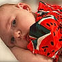 baby, close_up, infant, face, eyes, arm, red_clothing, patterned_clothing, resting, lying_down, skin, cute, child, portrait, soft_light, indoor, calm, young_child, head, expression