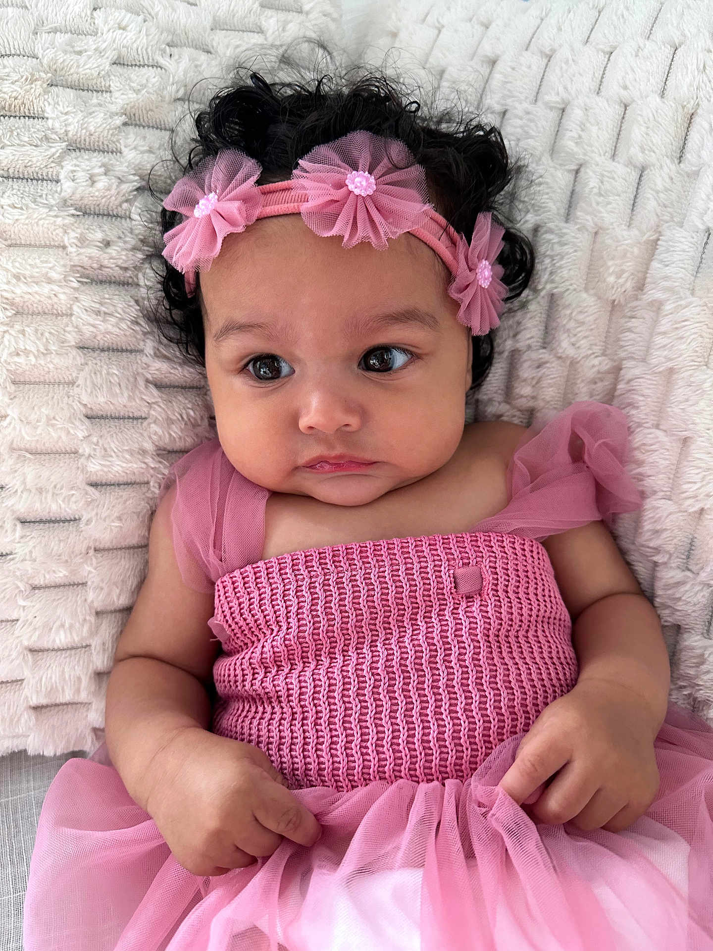 Harena a rejoint le concours — aidez-le/la à gagner de superbes lots ! adorable, baby, blanket, child, closeup, cloth, curly_hair, cute, expression, face, hands, headband, indoors, infant, person, pink_dress, portrait, resting, soft_texture, young_child