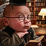 baby, child, glasses, graduation_cap, book, library, tweed_jacket, reading, indoors, furniture, lamp, hand, face, portrait, cute, thoughtful, small_book, sitting, person, background_blur