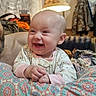 Kensleigh is registered to the contest to win money with this photo: baby, smiling, infant, cushion, patterned_fabric, indoor, lamp, curtain, sofa, person, happy, clothing, hand, face, head, living_room, coats, furniture, blanket, warm